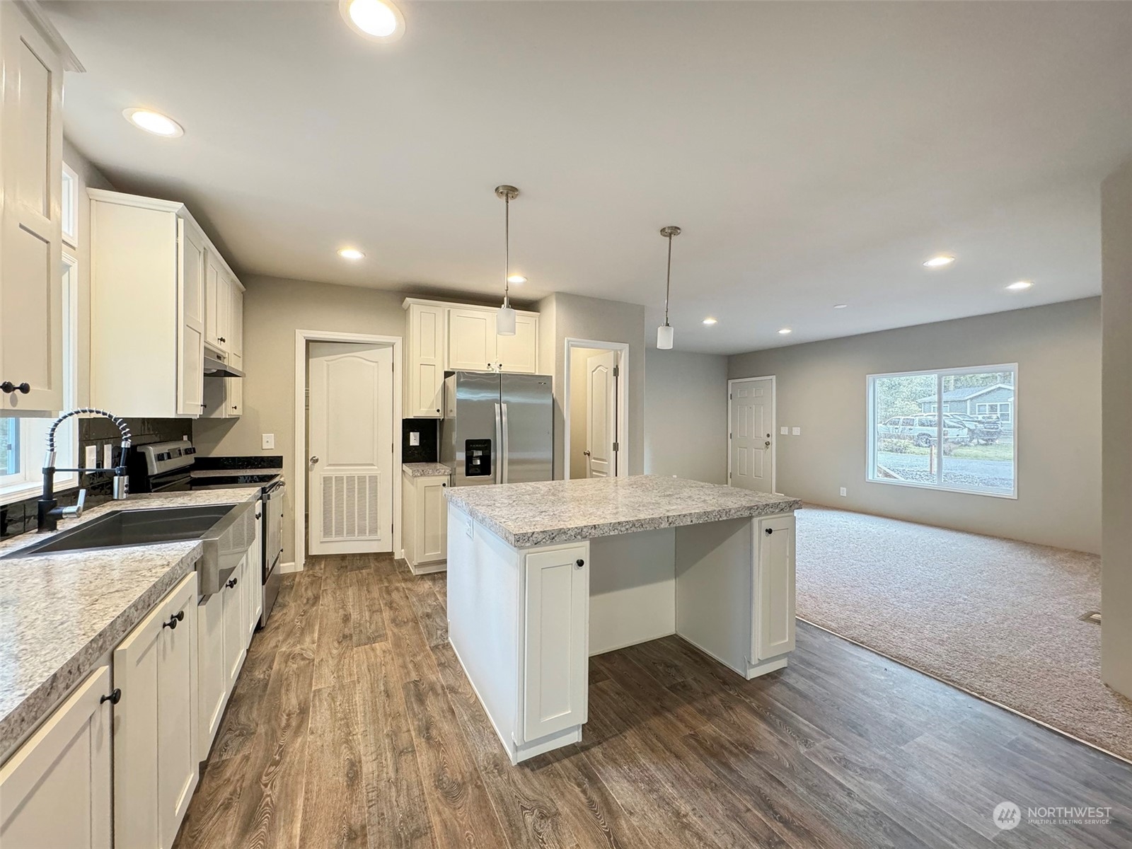 180 Madrona Way Sequim, WA 98382 - Photo 5 of 35 a large kitchen with a center island wooden floor stainless steel appliances and cabinets