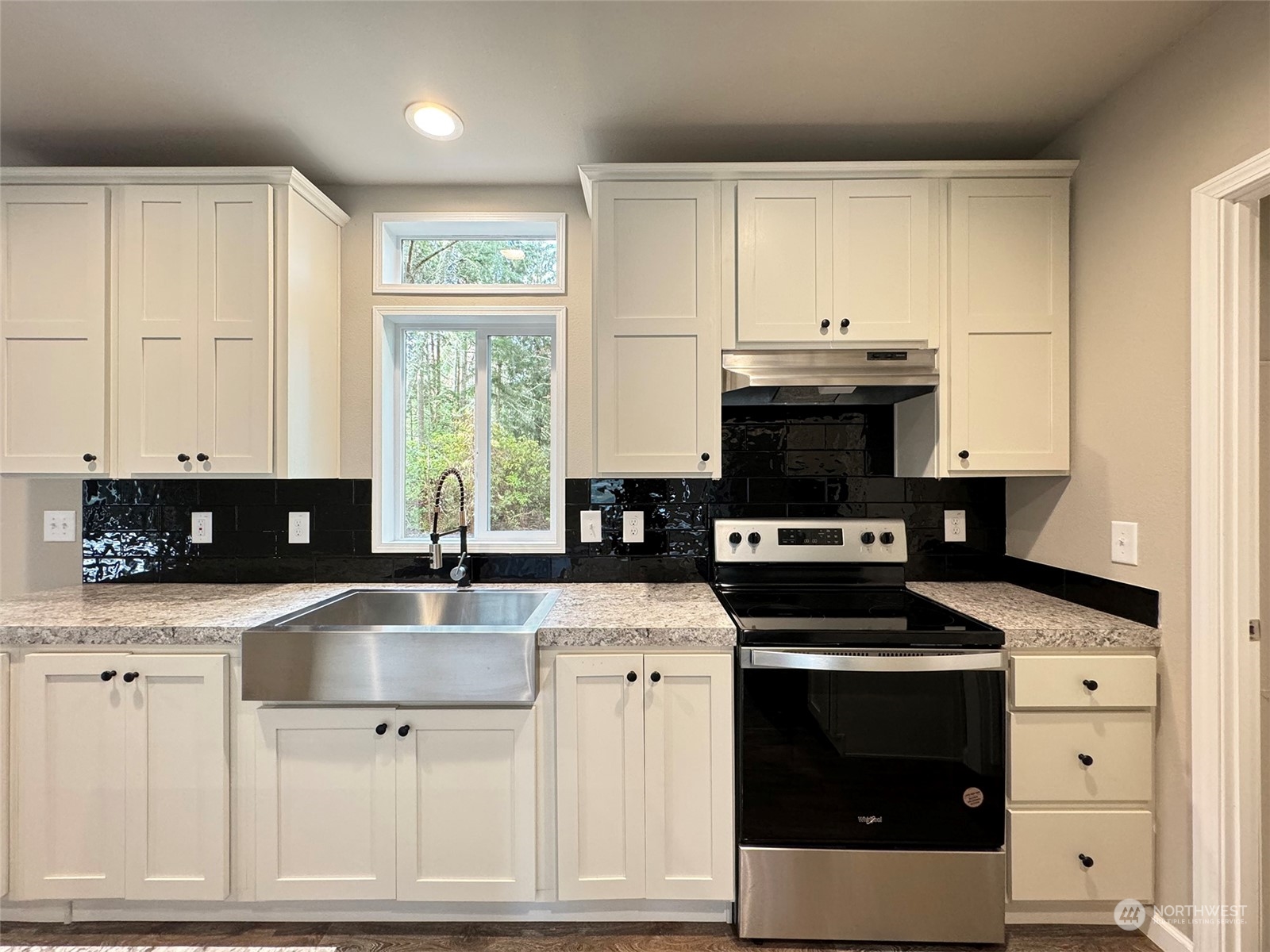 180 Madrona Way Sequim, WA 98382 - Photo 6 of 35 a kitchen with granite countertop a stove a sink and a microwave