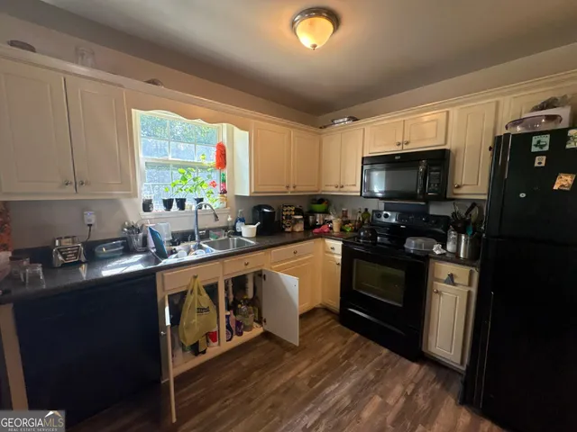 a kitchen with a sink a window a appliances and cabinets