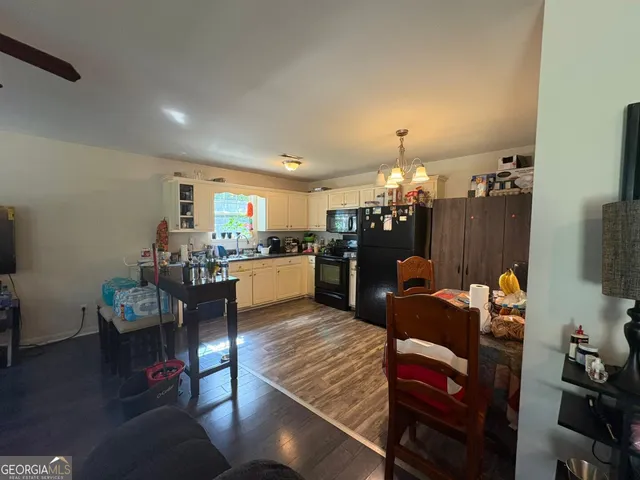 a living room with kitchen furniture dining table and a flat screen tv