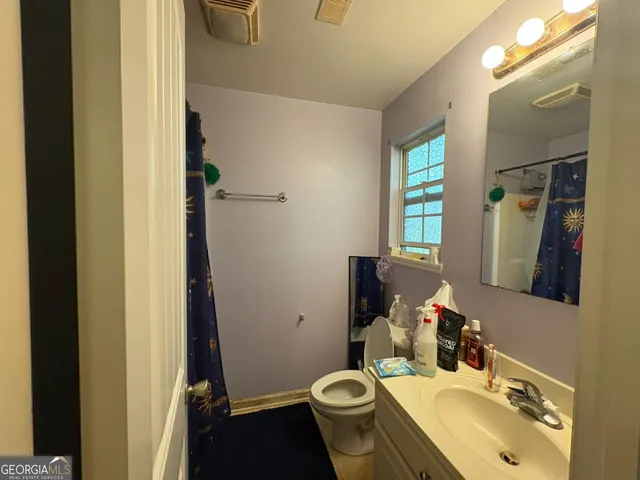 a bathroom with a sink toilet and mirror