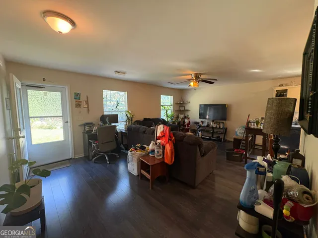 a living room with furniture or wooden floor and a flat screen tv