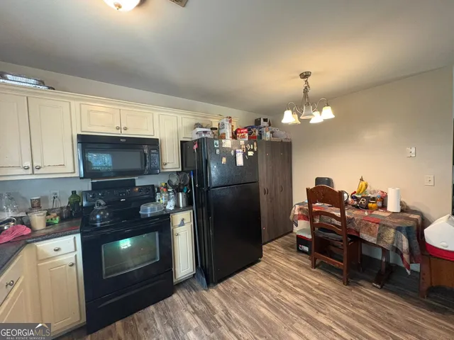 a kitchen with a refrigerator and a stove top oven