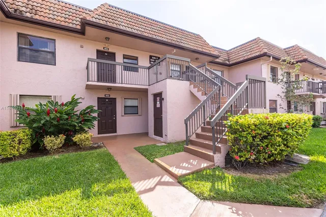 a view of a house with a small yard and plants
