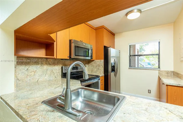 a kitchen with stainless steel appliances granite countertop a sink a stove and a microwave