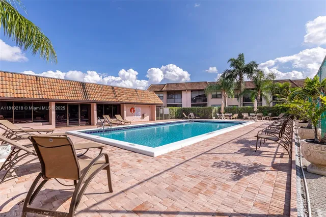 a view of a house with swimming pool and sitting area