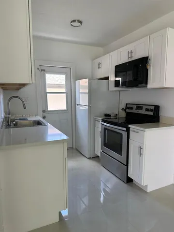 a kitchen with stainless steel appliances a sink stove and microwave