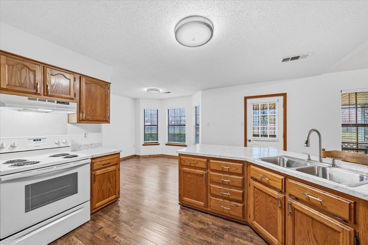 1426 Simmons Road Drummonds, TN 38023 - Photo 12 of 29 a kitchen with wooden floors and stainless steel appliances