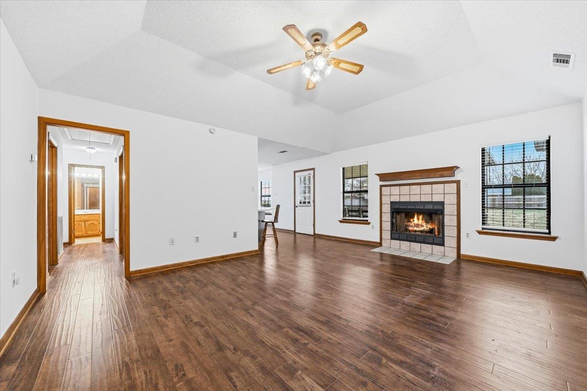 1426 Simmons Road Drummonds, TN 38023 - Photo 6 of 29 an empty room with wooden floor and a fireplace