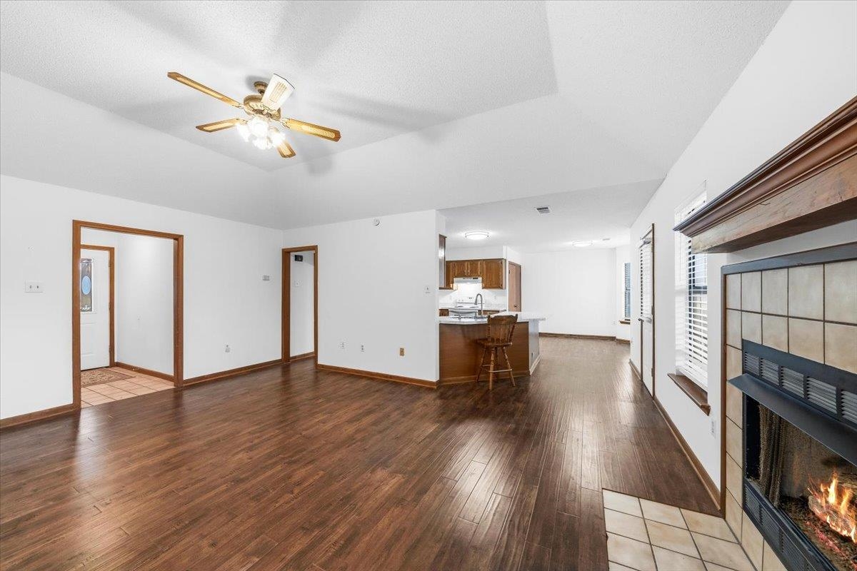 1426 Simmons Road Drummonds, TN 38023 - Photo 8 of 29 an empty room with wooden floor chandelier fan and windows