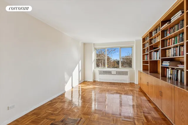 a view of a big room with wooden floor and windows