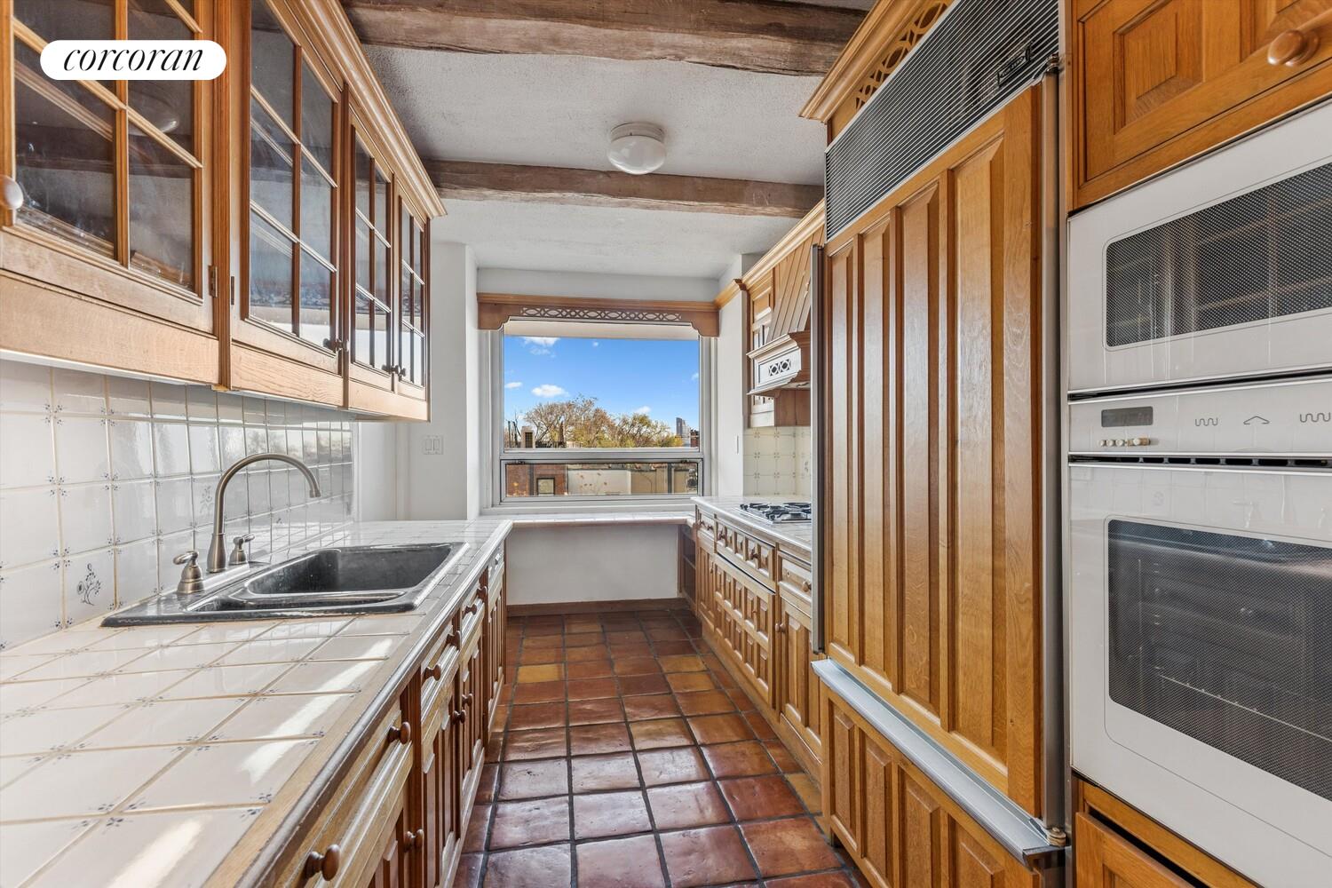 535 East 86th Street, Unit 6F Manhattan, NY 10028 - Photo 8 of 22 a kitchen with granite countertop a sink and a refrigerator