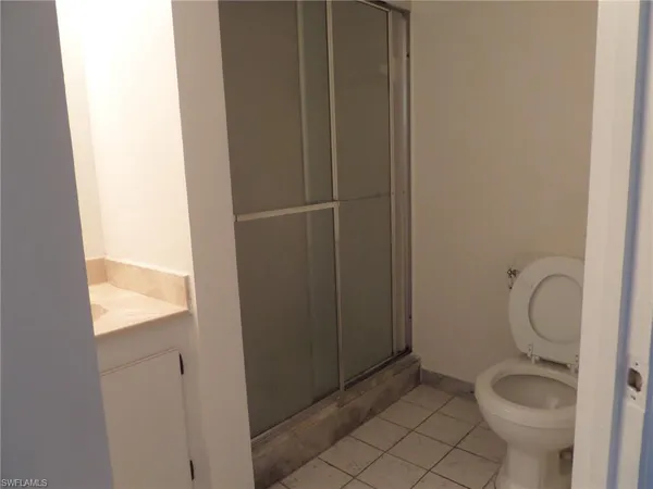 a bathroom with a granite countertop toilet and a sink