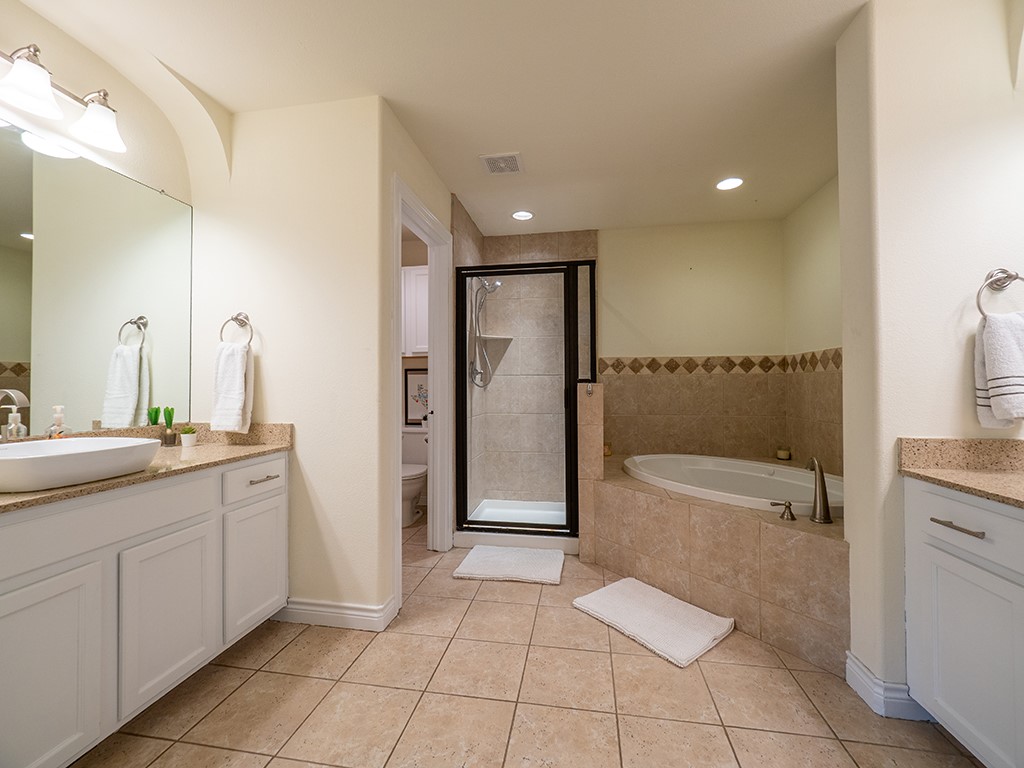 3609 Clawson Road, Unit B Austin, TX 78704 - Photo 14 of 28 Spacious bathroom featuring dual vanities with vessel sinks, a frameless glass shower, a soaking tub, and tile flooring