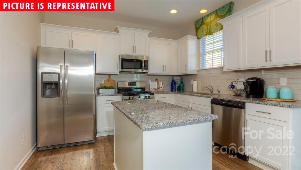 104 Kona Road Mooresville, NC 28117 - Photo 15 of 38 a kitchen with kitchen island granite countertop a refrigerator a sink a stove and white cabinets