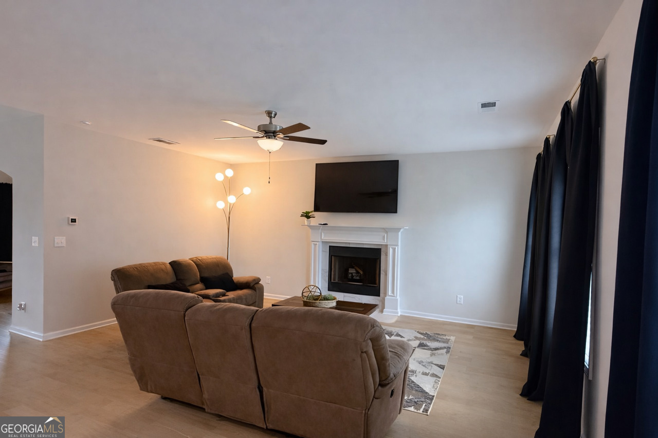 4355 Cornwall Drive Forsyth, GA 31029 - Photo 5 of 23 a living room with furniture a fireplace and a flat screen tv