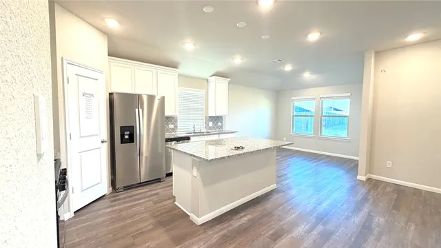 a view of kitchen with stainless steel appliances granite countertop a refrigerator and a sink