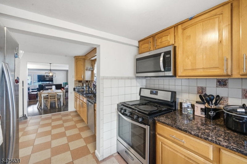 60 Westervelt Place Lodi, NJ 07644 - Photo 17 of 48 a kitchen with stainless steel appliances granite countertop a stove a sink and a microwave
