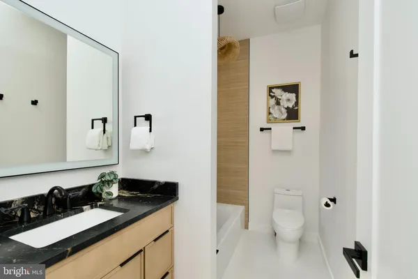 a bathroom with a granite countertop sink toilet and shower