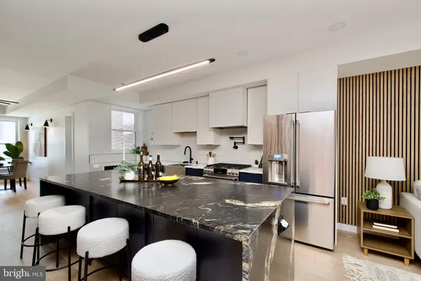 a kitchen with refrigerator and chairs