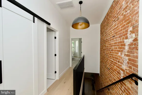 a view of a hallway with wooden floor and staircase