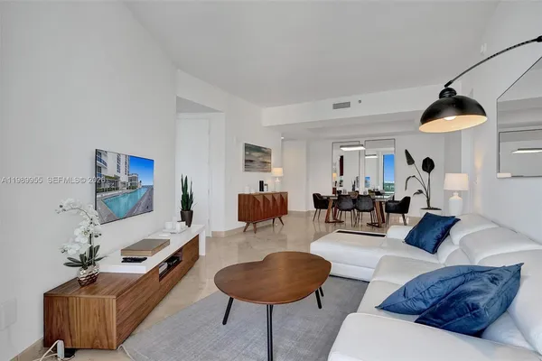 a living room with furniture and a view of kitchen