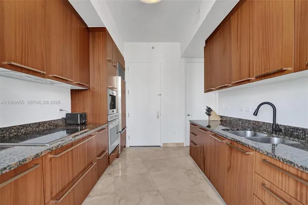 a kitchen with stainless steel appliances granite countertop a sink stove and cabinets