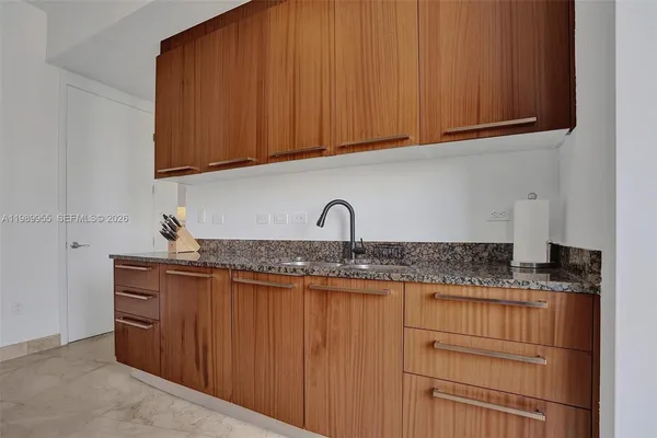 a kitchen with granite countertop a sink and cabinets
