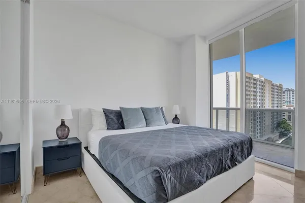 a large bed sitting in a bedroom next to a window