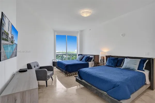 a bedroom with furniture and a large window