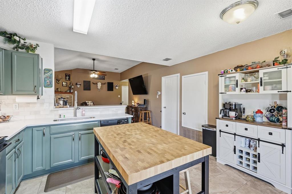 205 Comanche Trail Krum, TX 76249 - Photo 11 of 24 a kitchen with a stove a sink dishwasher and cabinets with wooden floor