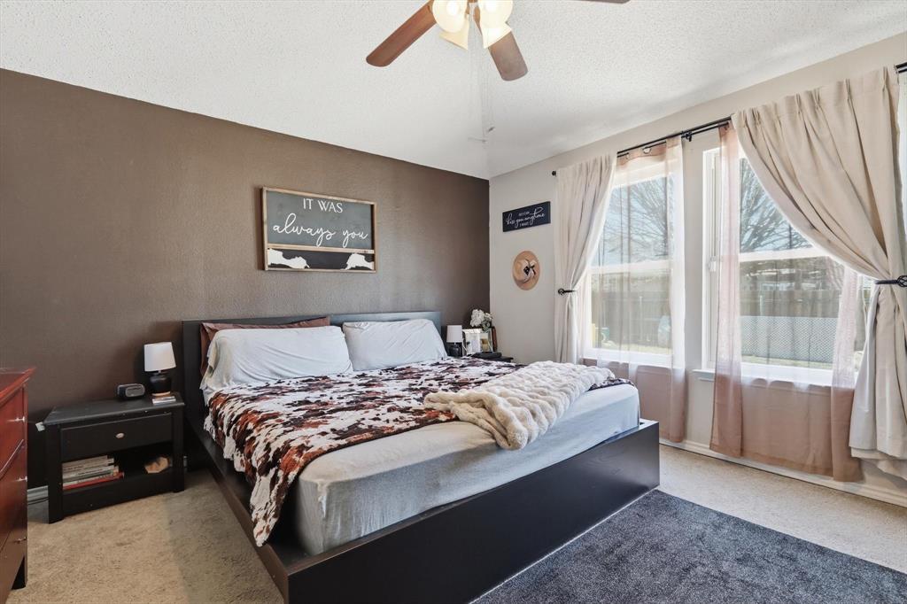 205 Comanche Trail Krum, TX 76249 - Photo 15 of 24 a bedroom with a large bed and a large window