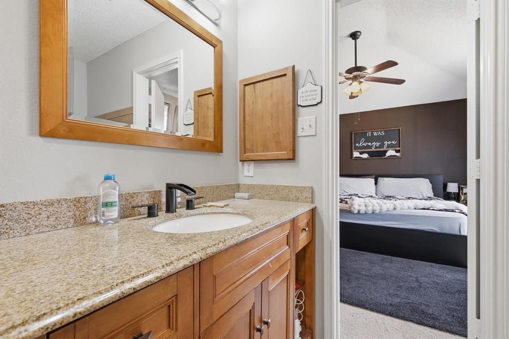 205 Comanche Trail Krum, TX 76249 - Photo 18 of 24 a bathroom with a granite countertop sink and a mirror