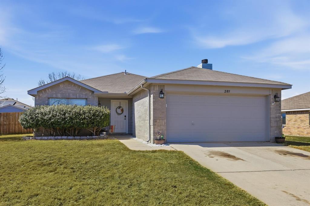 205 Comanche Trail Krum, TX 76249 - Photo 2 of 24 a front view of a house with a yard