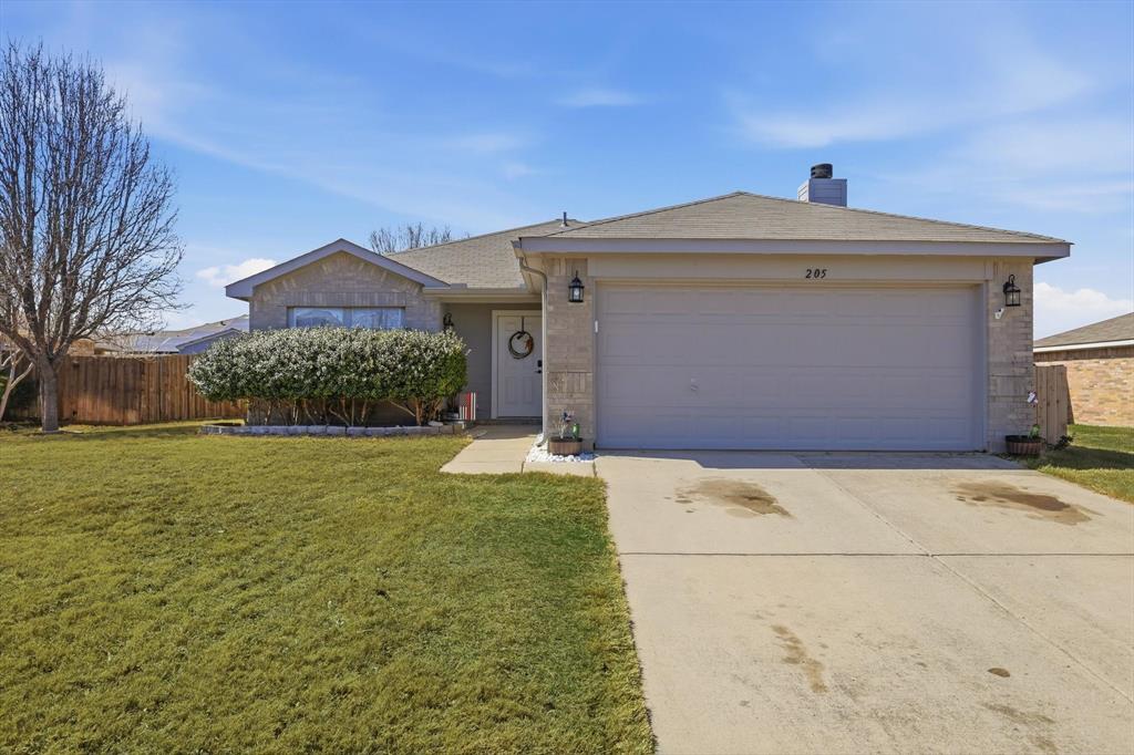 205 Comanche Trail Krum, TX 76249 - Photo 3 of 24 a front view of a house with garden