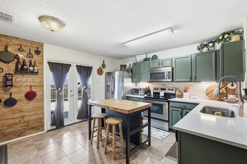 205 Comanche Trail Krum, TX 76249 - Photo 8 of 24 a kitchen with a stove a refrigerator and a stove