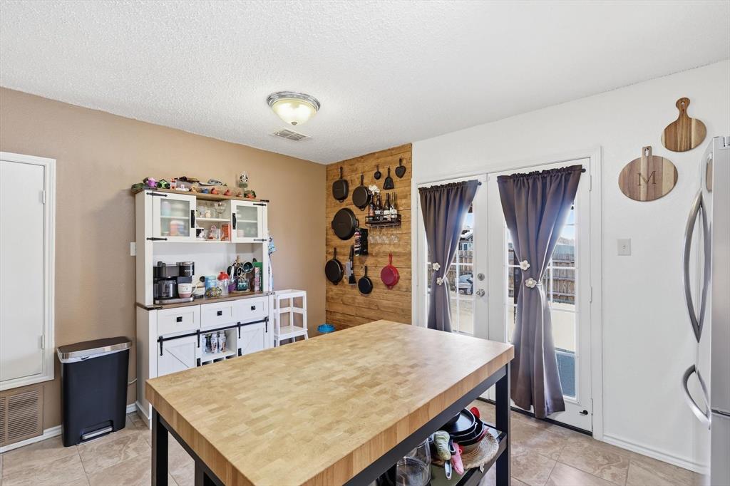 205 Comanche Trail Krum, TX 76249 - Photo 10 of 24 a kitchen with stainless steel appliances granite countertop a table chairs and refrigerator