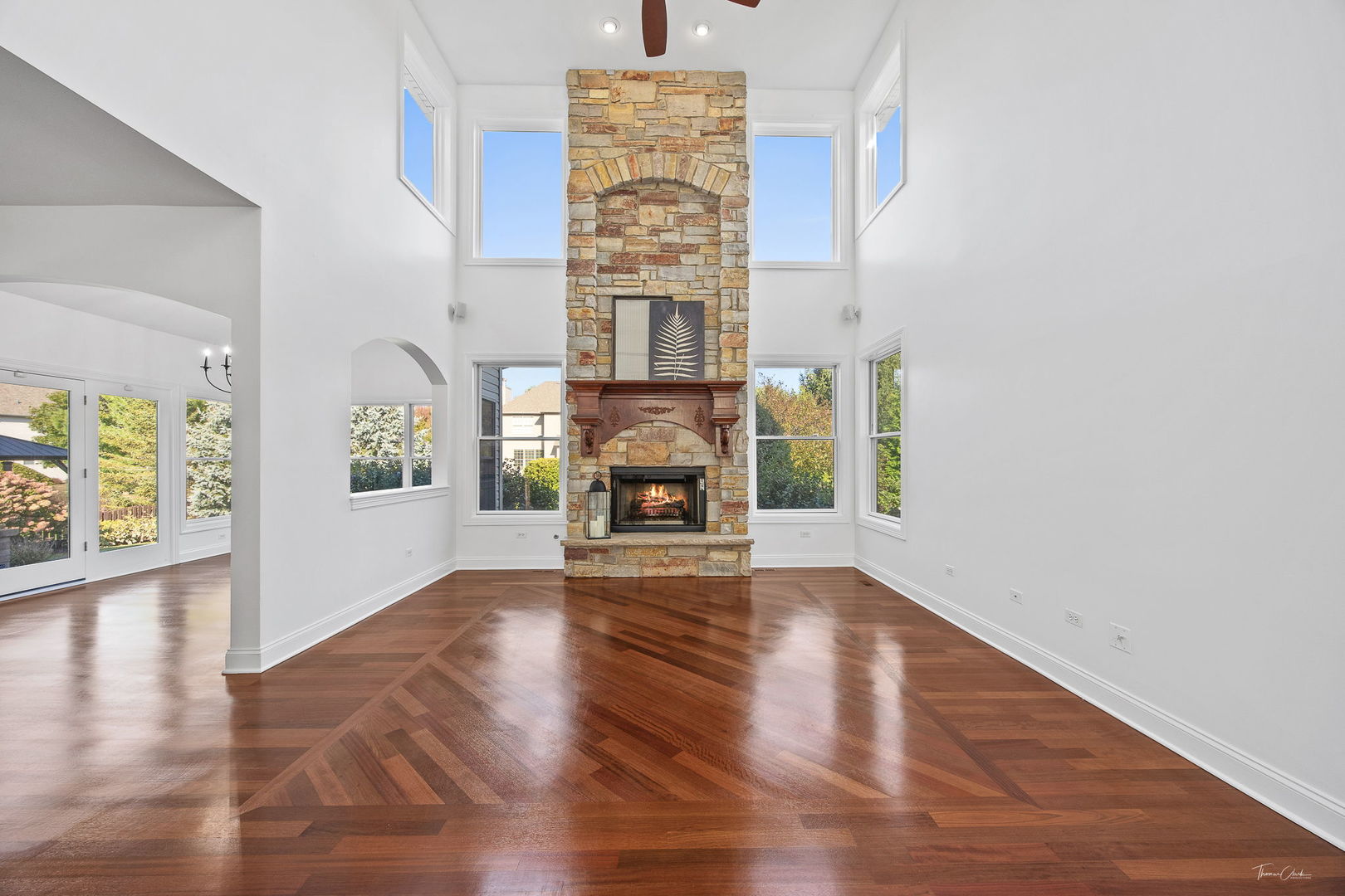 12929 Alpine Way Plainfield, IL 60585 - Photo 11 of 55 wooden floor fireplace and windows in an empty room