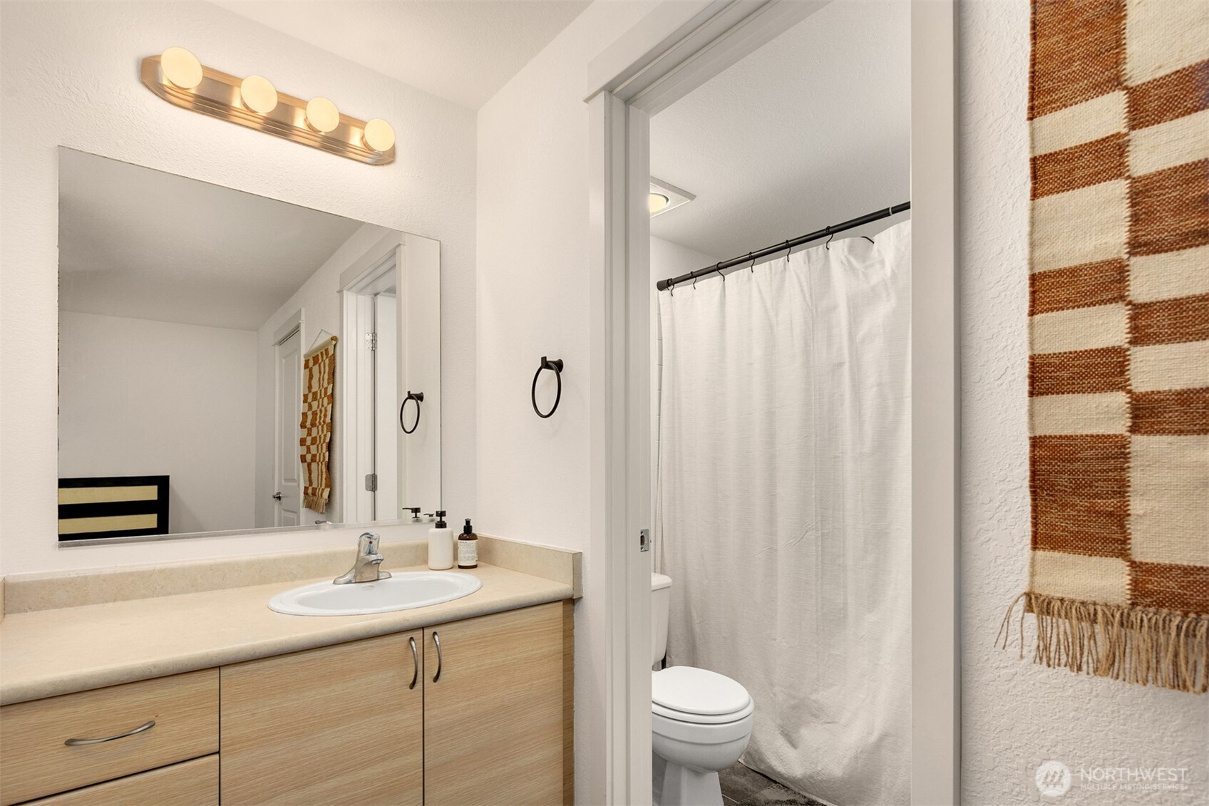 215 9th Street, Unit D102 Kirkland, WA 98033 - Photo 17 of 29 a bathroom with a sink a toilet a shower and a mirror