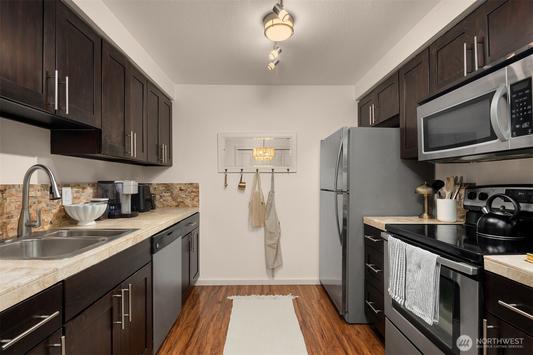 215 9th Street, Unit D102 Kirkland, WA 98033 - Photo 10 of 29 a kitchen with a sink a refrigerator cabinets and a counter top space