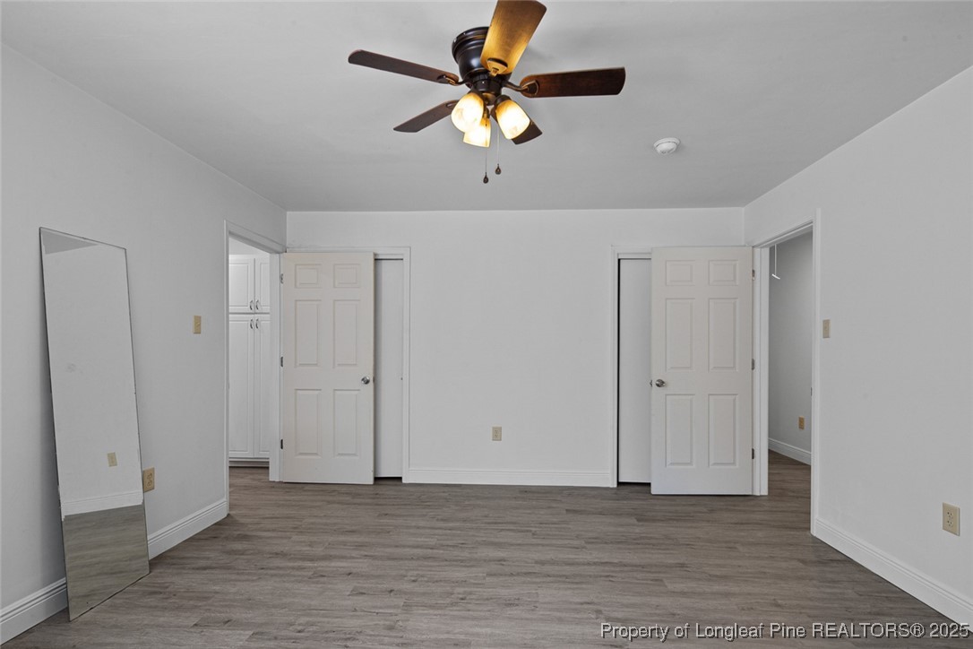 613 East 3rd Avenue Red Springs, NC 28377 - Photo 18 of 37 a view of an empty room with window a ceiling fan and wooden floor