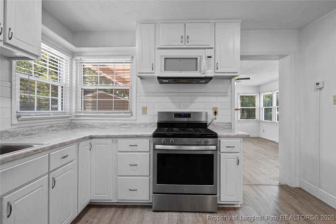 613 East 3rd Avenue Red Springs, NC 28377 - Photo 21 of 37 a kitchen with stainless steel appliances white cabinets granite and a stove top oven