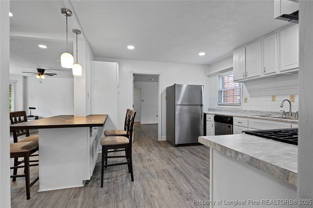 613 East 3rd Avenue Red Springs, NC 28377 - Photo 23 of 37 a kitchen with stainless steel appliances a refrigerator a stove a sink and chairs