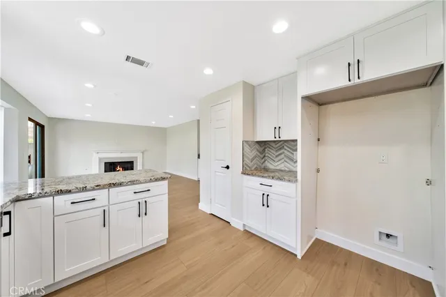 a kitchen with white cabinets and appliances