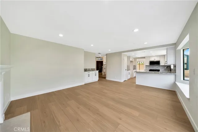 a view of an empty room with furniture and a window