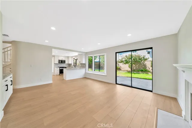 an empty room with windows and fireplace
