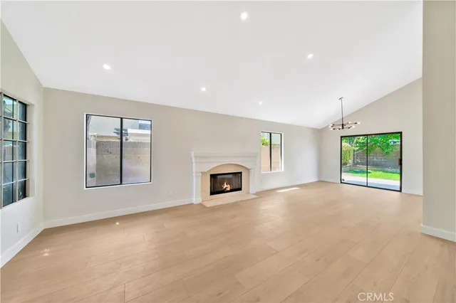 an empty room with windows and fireplace