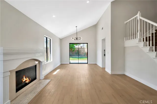 a view of empty room with wooden floor and fireplace