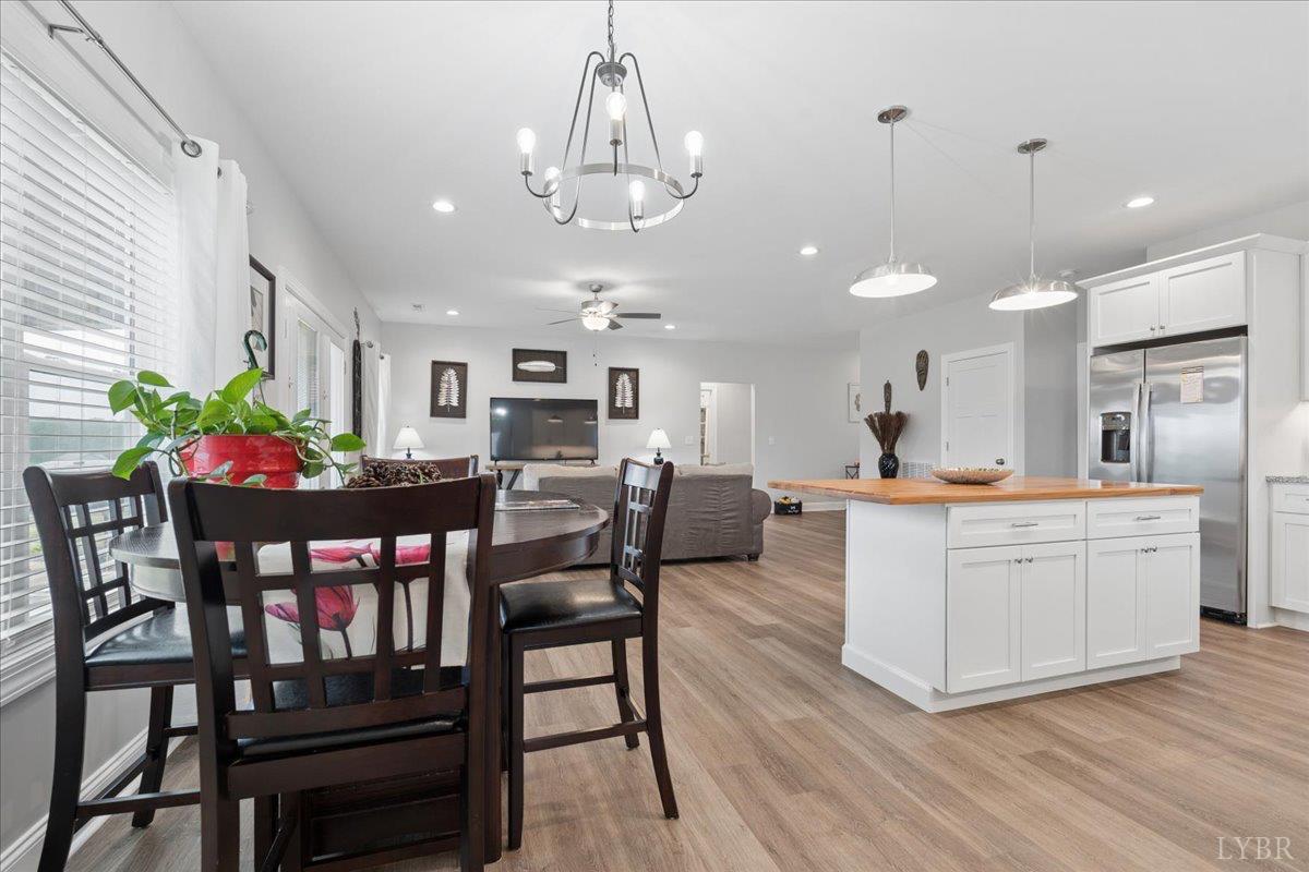 578 Collins Ferry Road Gladys, VA 24554 - Photo 11 of 36 a kitchen with stainless steel appliances kitchen island granite countertop a dining table chairs and white cabinets