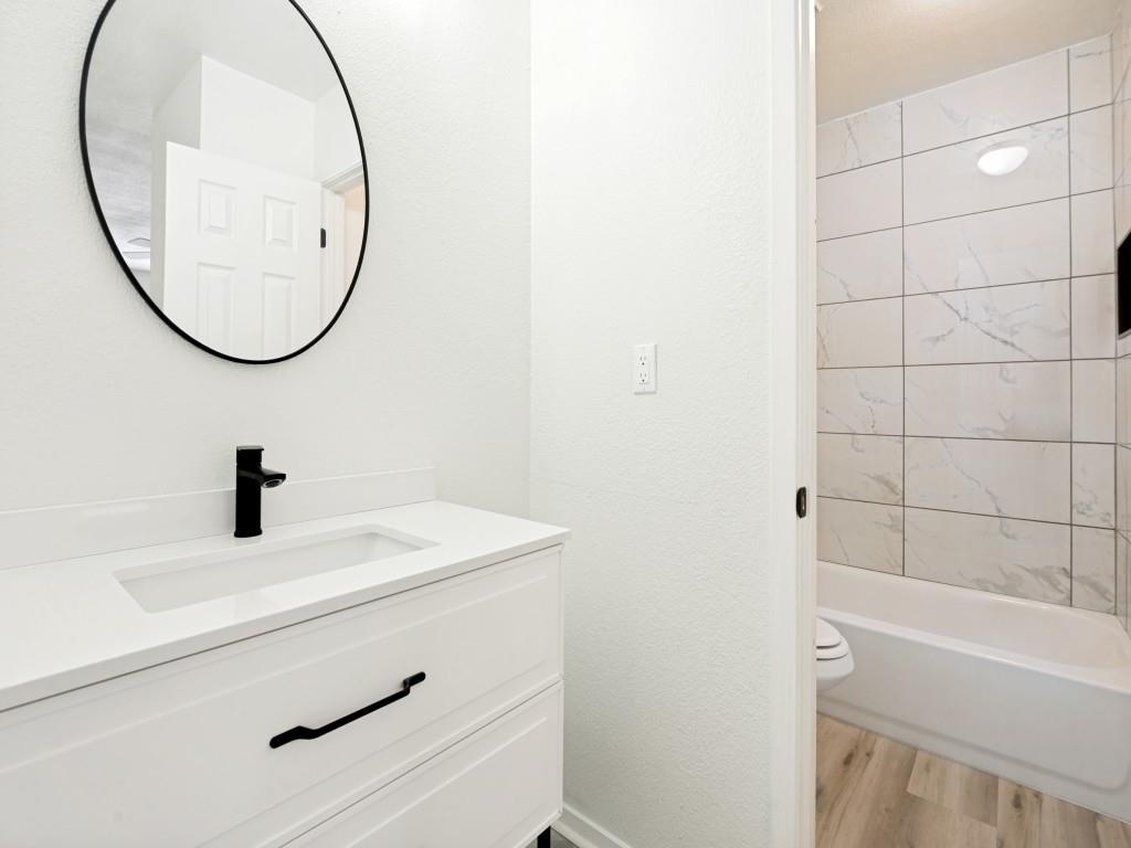 2240 Tarpley Road, Unit 92 Carrollton, TX 75006 - Photo 18 of 22 a bathroom with a sink a mirror and a bathtub